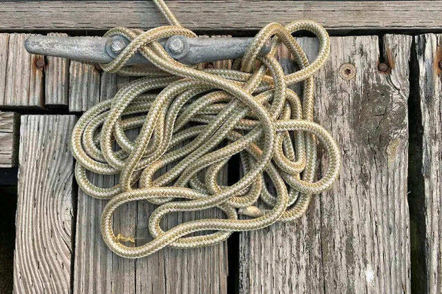 Braided mooring line secured to a cleat on a wooden dock